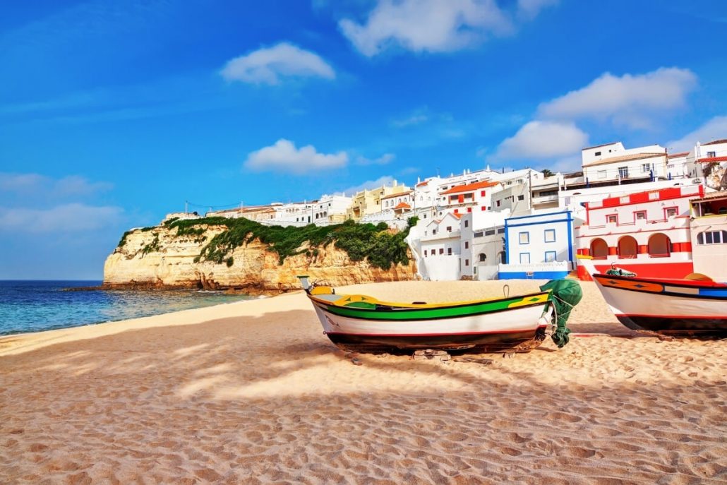 fishing boats on a beach in front of colourful houses at Carvoeiro, the Algarve