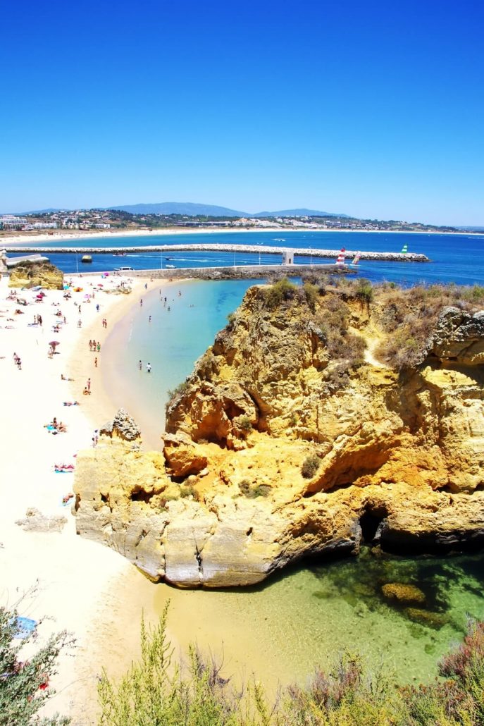 A picture of cliffs leading to a golden sandy beach in the Algarve